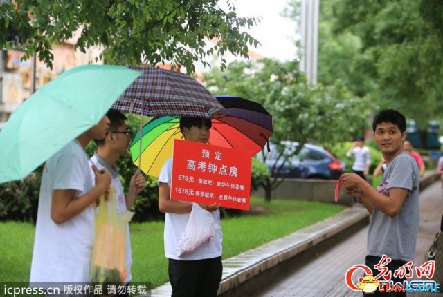 2014年6月6日下午，北京，高考考点北大附中路口的两边人行道上，几位“黄牛”冒雨向过往的家长人群宣传高考钟点房。