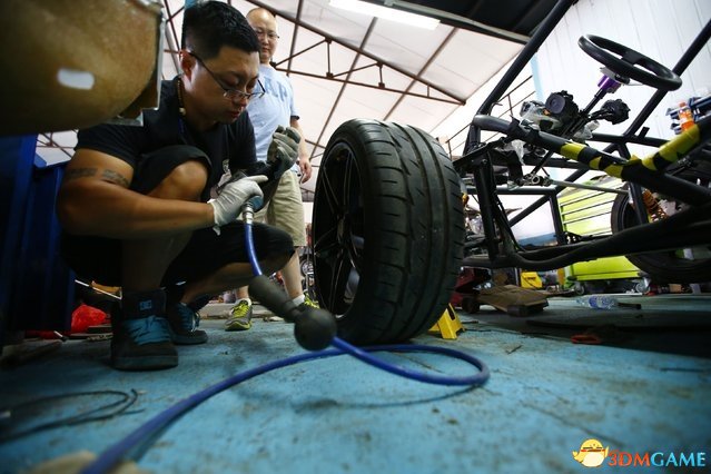 2014年8月21日，北京郊区，王宇（中间）正在车库内制造山寨版的T-Rex摩托车。