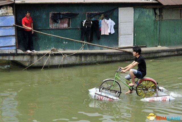  图中是武汉当地人李志强岑在2010年6月16日在汉江上测试自己设计的水上自行车。