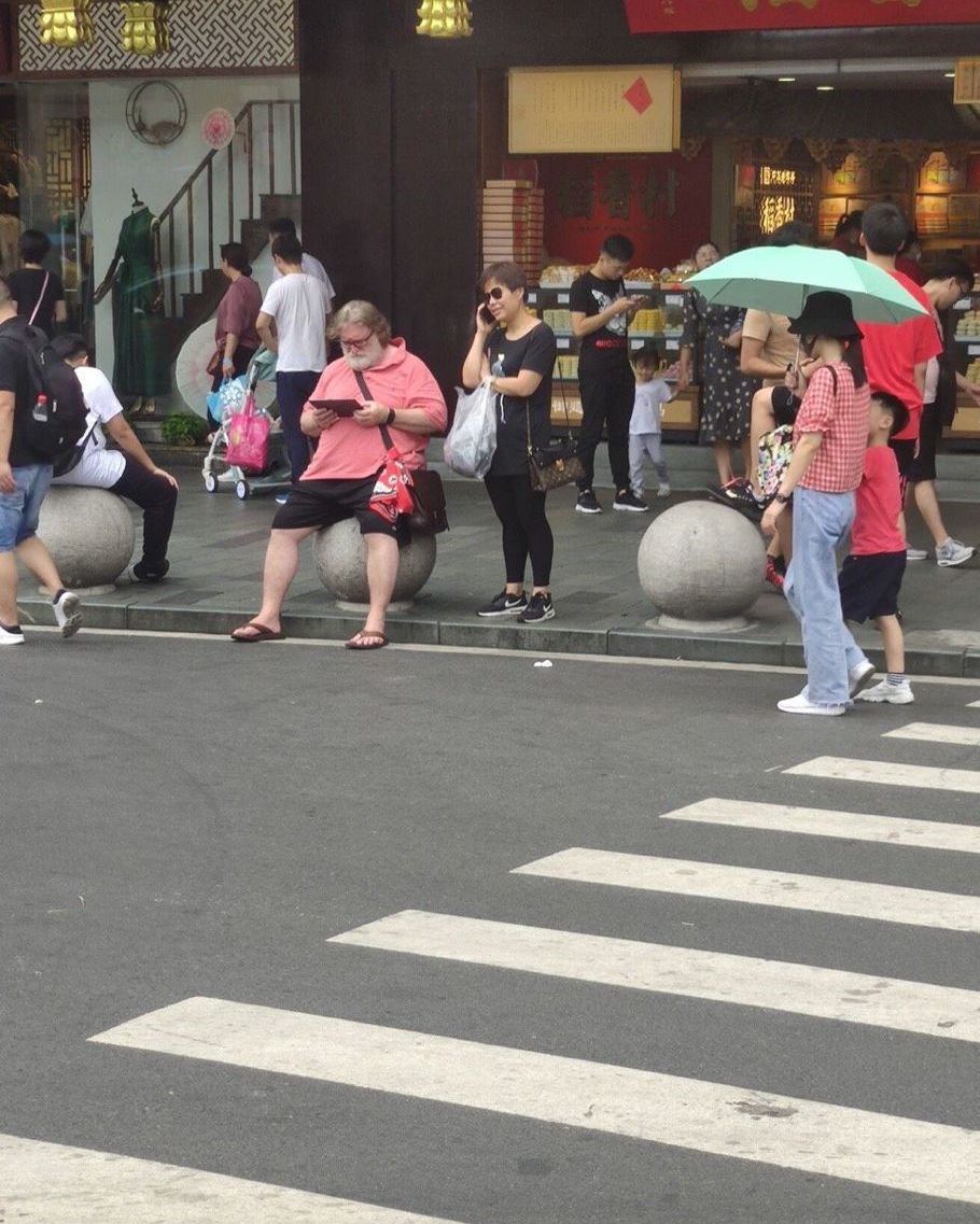网友正在上海街头看到G肥：坐正在石墩上玩仄板