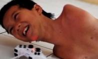 Indonesian 12 -year -old boy born with no limbs to use chin to control the handle to play games